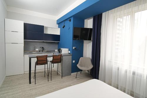 a kitchen with blue walls and a table and chairs at Sweet Home Apart-Hotel in Yerevan