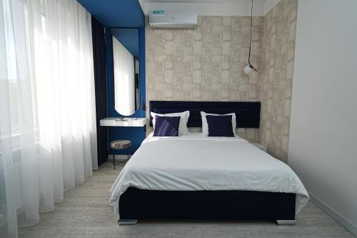 a bedroom with a large bed with blue walls at Sweet Home Apart-Hotel in Yerevan