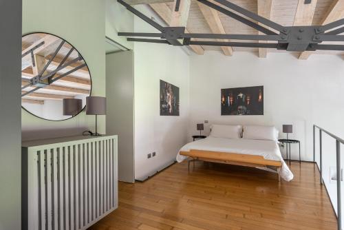 1 dormitorio con cama blanca y suelo de madera en Cala Loft by Wonderful Italy, en Palermo