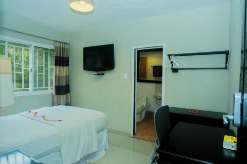 a hotel room with a bed and a chair at The Jam Lodge in Freetown