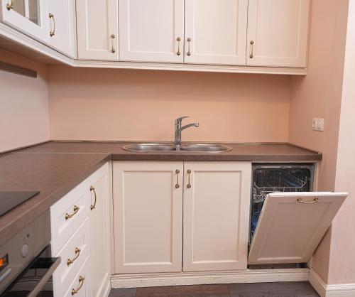 a kitchen with white cabinets and a sink at Sweet Home Apart-Hotel in Yerevan