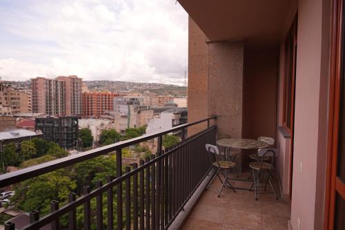 a balcony with a table and chairs and a view at Sweet Home Apart-Hotel in Yerevan