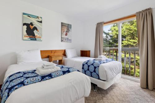 een kamer met 3 bedden en een raam bij 10 Bedroom Executive Chalet w Hot Tub in Blue Mountains