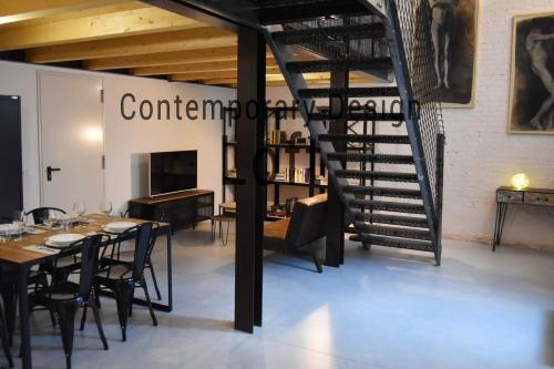 Contemporary Design Loft & Apartment Padova في بادوفا: درج حلزوني أسود في غرفة طعام مع طاولة