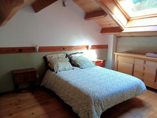 une chambre avec un lit avec une couette bleue et une fenêtre dans l'établissement La forge, à Escaro
