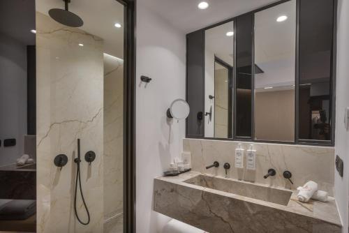 a bathroom with a sink and a mirror at Ethereal White Resort Hotel & Spa - Adults Only in Heraklio Town