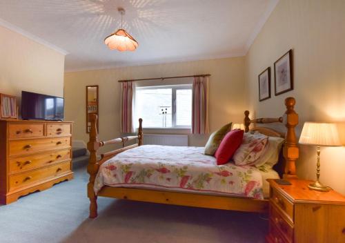um quarto com uma cama, uma cómoda e uma janela em Lower Dean Farm em Trentishoe