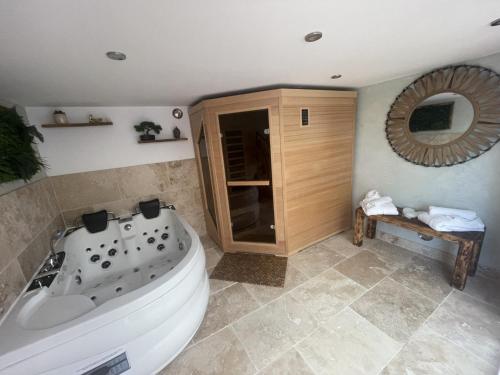a bathroom with a large tub and a mirror at Alba zen & spa in Villefranche-de-Lauragais