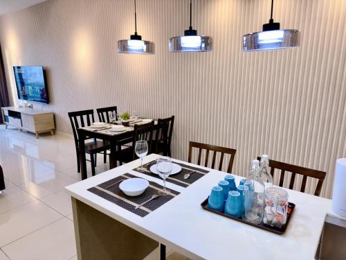 a dining room with a table with wine glasses and chairs at MidValley Southkey Mosaic 6-9pax Netflix-SmartTV70inch in Johor Bahru
