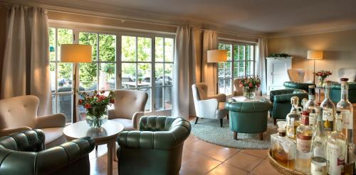 a waiting room with chairs and bottles of wine at Hotel Pienzenau Am Schlosspark in Merano