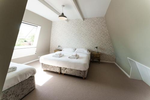 a bedroom with two beds and a window at Vineyard Oast Sleeps 25 in Wavehorne