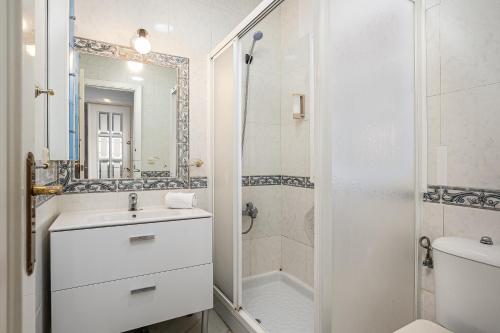 a white bathroom with a sink and a shower at CHALET ESTRIBOR, 27 in Novo Sancti Petri