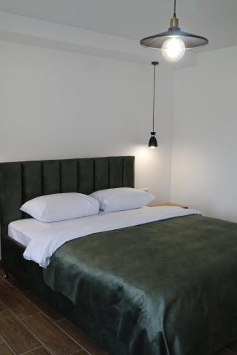 a large bed with a green headboard and white pillows at Aqua Hotel in Solotvyno