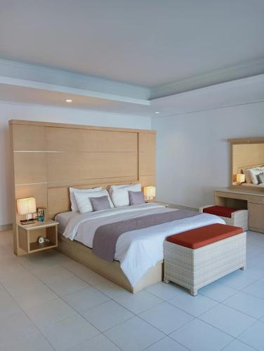 a bedroom with a large bed with a wooden headboard at Glisten Up Villa Beach Side Sanur! in Sanur