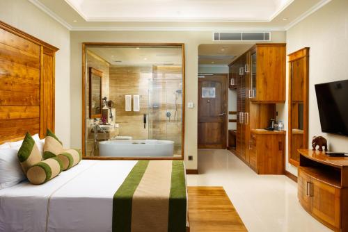 a bedroom with a large bed and a bathroom at Araliya Beach Resort & Spa Unawatuna- Where you meet the sea all year in Unawatuna