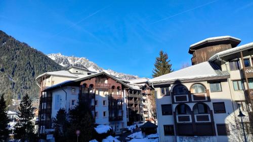 a group of buildings with mountains in the background at charmant appartement 2-4 personnes coeur de chamonix in Chamonix-Mont-Blanc