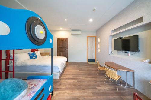 una camera da letto con un letto a castello e una tv di Mushroom Garden a Dongshan