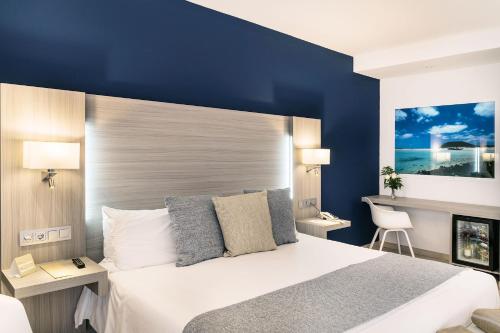 a bedroom with a large bed with a blue wall at Royal Palm Resort & Spa - Adults Only in Playa Jandia