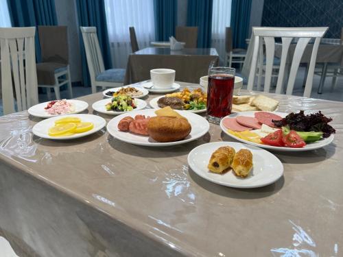 a table with plates of food on it at DSF GARDEN HOTEL in Yakkasaray
