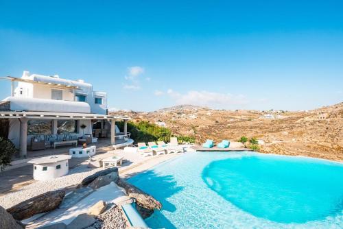 a villa with a swimming pool and a house at 6 bedrooms villa at Platis Gialos 800 m away from the beach with sea view private pool and enclosed garden in Paradise Beach