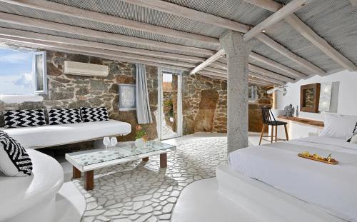 a bedroom with white furniture and a stone wall at 6 bedrooms villa at Platis Gialos 800 m away from the beach with sea view private pool and enclosed garden in Paradise Beach