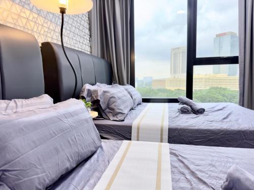 a hotel room with two beds and a window at MidValley Southkey Mosaic 6-9pax Netflix-SmartTV70inch in Johor Bahru