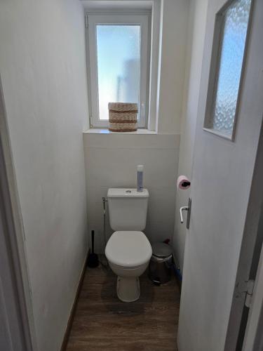 Elle comprend une petite salle de bains pourvue de toilettes et d'une fenêtre. dans l'établissement Nid douillet palois vue Pyrénées - Parking, à Pau