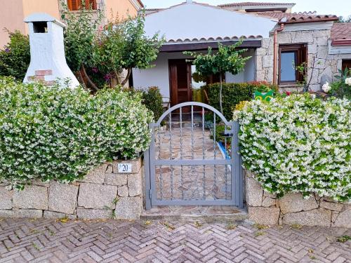 um portão em frente a uma casa com flores em Frank's Home em Tanaunella