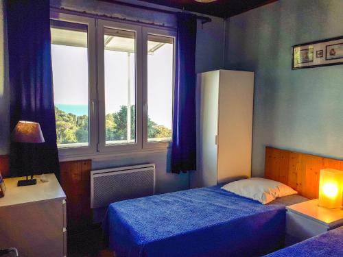 une chambre avec deux lits et une fenêtre dans l'établissement L'escapade, à Rayol-Canadel-sur-Mer