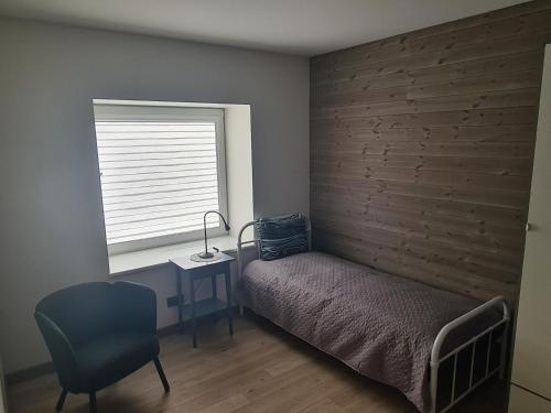 een slaapkamer met een bed, een bureau en een raam bij Kambarių nuoma Naujojoje Akmenėje in Naujoji Akmenė