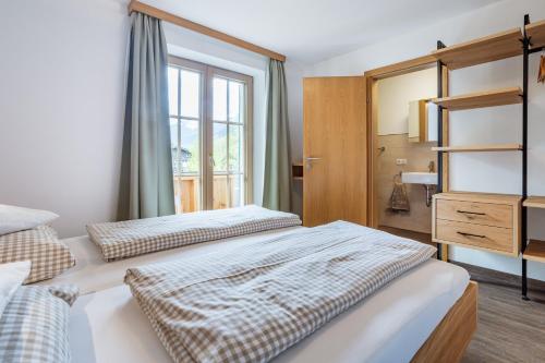a bedroom with two beds and a mirror at Feriennest Leitner in Maria Alm am Steinernen Meer