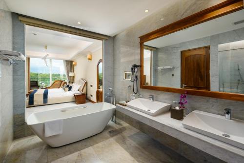 baño con 2 lavabos y espejo grande en Araliya Beach Resort & Spa Unawatuna- Where you meet the sea all year en Unawatuna