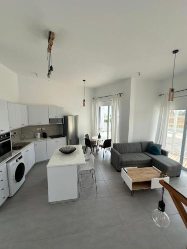cocina y sala de estar con sofá y mesa en WaveBreeze Villas en Pafos