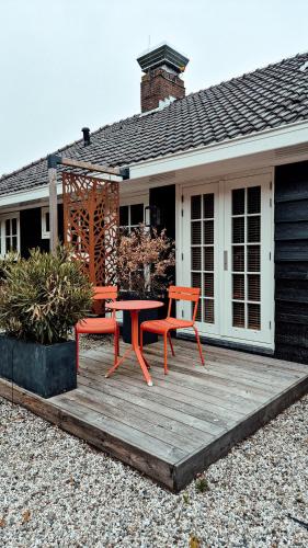 a patio with a table and chairs on a house at Zoomers aan het Bos in Castricum