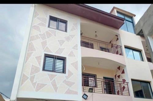 a white building with windows and a balcony at Hacienda Residence - Solar Energized in Yaoundé