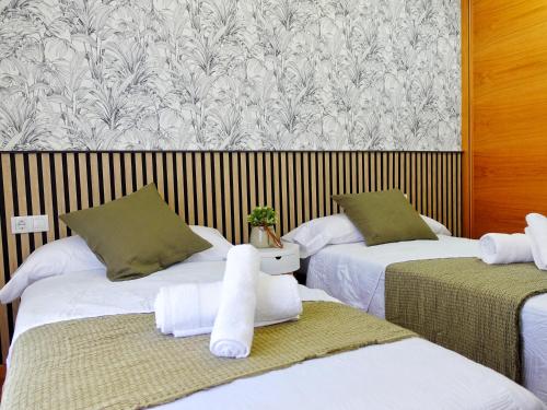 a room with two beds with white towels on them at Atalaia Apartment Foz in Foz