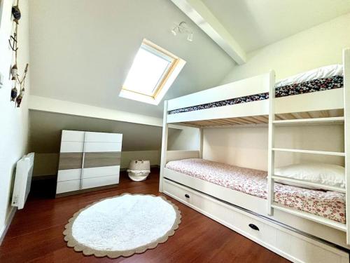 une chambre avec deux lits superposés et une fenêtre dans l'établissement Agréable appartement proche de la mer, à Arcachon