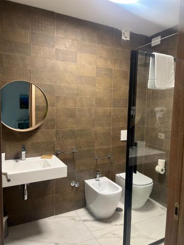 a bathroom with a sink and a toilet and a mirror at Greenlove in Agerola