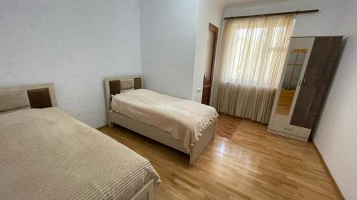 a bedroom with two beds and a door to a hallway at Green Paradise in Ijevan