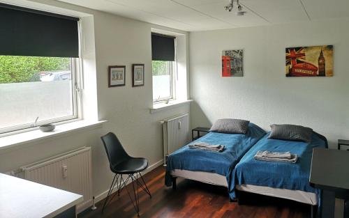 um quarto com uma cama e uma cadeira em H&M Homes Apartments em Aarhus