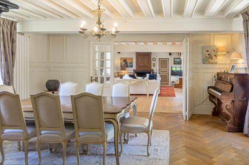 - une salle à manger avec une table, des chaises et un piano dans l'établissement Maison chaleureuse de 4 à 12 personnes, à Neuville-aux-Bois