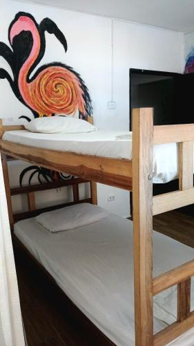 a bunk bed with a flamingo painted on the wall at Kimara Tayrona Hostel in El Zaino