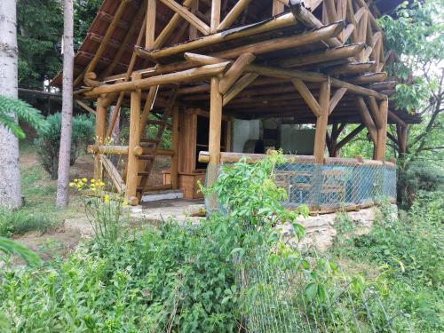 a wooden structure in the middle of a garden at Farma Zdrowia in Znamirowice