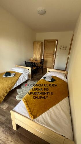 a room with two beds and a table in it at Apartamenty u Chlipały in Krośnica