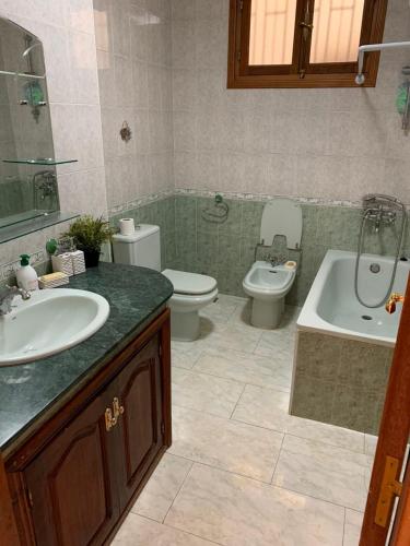 a bathroom with a sink and a toilet and a tub at Miramar Martil à 2 min de la plage in Martil