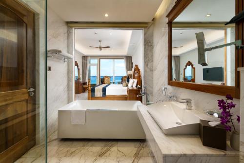 a bathroom with a large white tub and a sink at Araliya Beach Resort & Spa Unawatuna- Where you meet the sea all year in Unawatuna