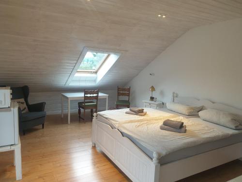 a bedroom with a bed and a table and a window at Landhaus Bad Rotenfels - Bethel in Gaggenau