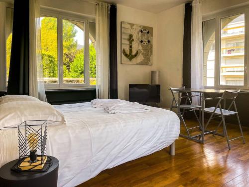 une chambre avec un lit, une table et des chaises dans l'établissement la maison du centre, à Lannion