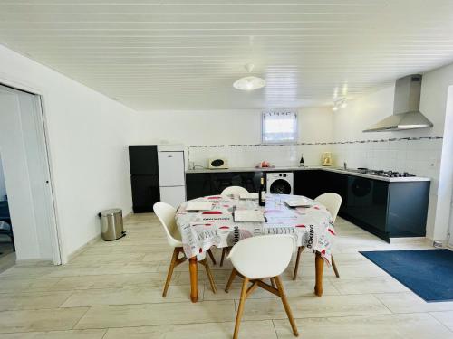 une salle à manger avec une table et des chaises dans une cuisine dans l'établissement La Sionnaise, à Plage-des-Demoiselles