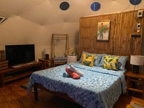 a bedroom with a bed with a teddy bear on it at Glamping Dome Dauin Beach Resort in Dauin